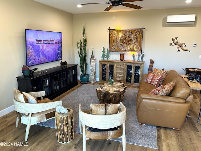 living room with wood-type flooring, a wall mounted AC, and ceiling fan