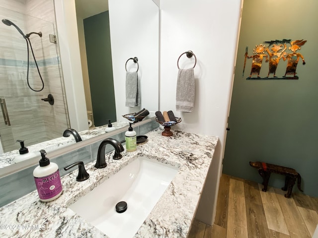 bathroom featuring toilet, a shower with door, hardwood / wood-style flooring, and vanity