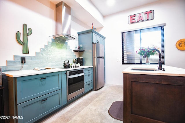 kitchen with appliances with stainless steel finishes, extractor fan, sink, backsplash, and blue cabinetry