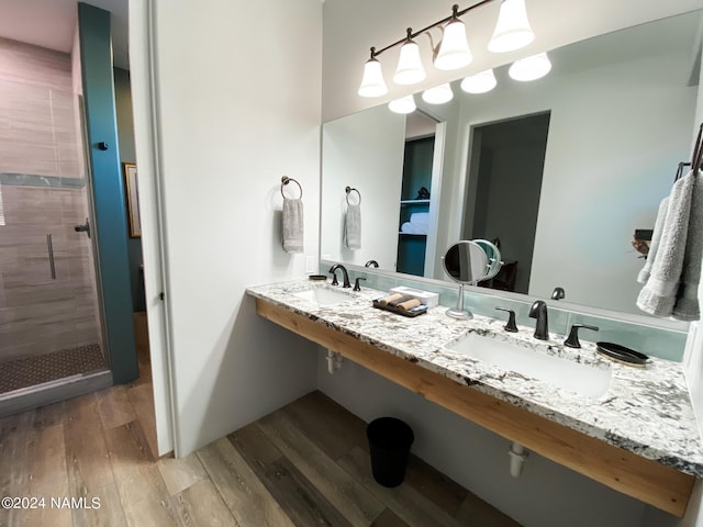 bathroom featuring hardwood / wood-style flooring, double sink, and an enclosed shower