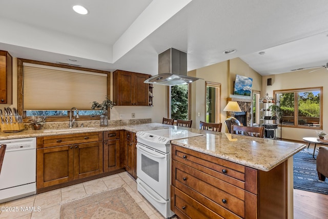 2303 N Plateau Dr, Flagstaff, AZ 86004 - kitchen featuring white appliances, island exhaust hood, a peninsula, vaulted ceiling, and a fireplace