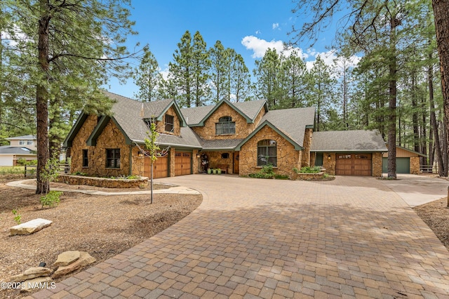 2300 W Kiltie Ln, Flagstaff, AZ 86005 - view of front facade featuring stone siding, driveway, a garage, and roof with shingles