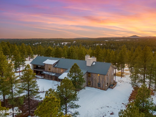 snowy aerial view with a view of trees