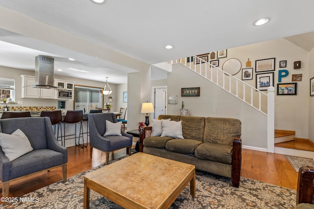 living room with baseboards, stairway, wood finished floors, and recessed lighting