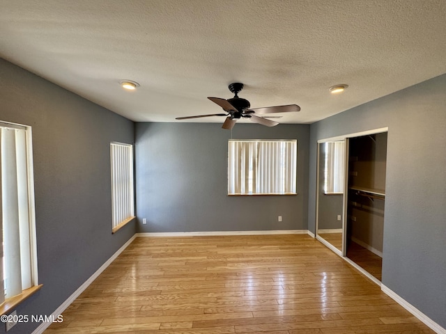 7840 Cowboy Way, Flagstaff, AZ 86004 - unfurnished bedroom with wood-type flooring, a closet, a textured ceiling, baseboards, and a ceiling fan