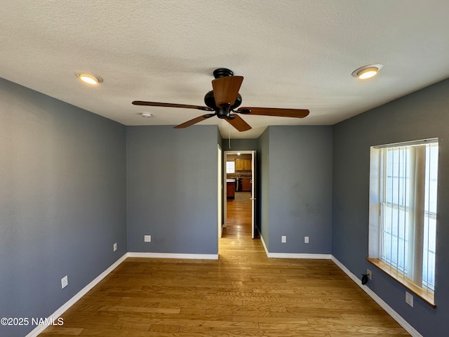 7840 Cowboy Way, Flagstaff, AZ 86004 - unfurnished room with ceiling fan, wood finished floors, a textured ceiling, and baseboards