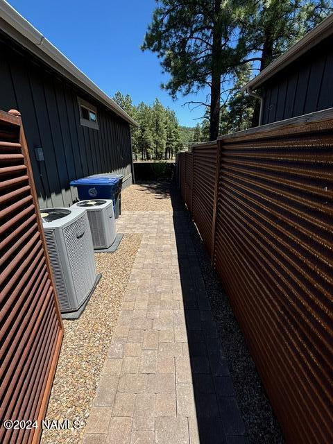 view of property exterior with central air condition unit and a patio area