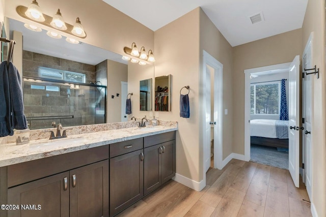 bathroom with hardwood / wood-style flooring, toilet, a shower with shower door, and vanity