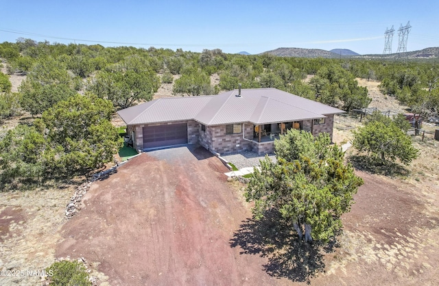 1384 W Canvasback Trl, Williams, AZ 86046 - view of front of property with a porch, a garage, dirt driveway, a metal roof, and stone siding
