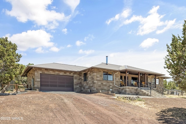 1384 W Canvasback Trl, Williams, AZ 86046 - view of front of home with dirt driveway, covered porch, a garage, and a metal roof