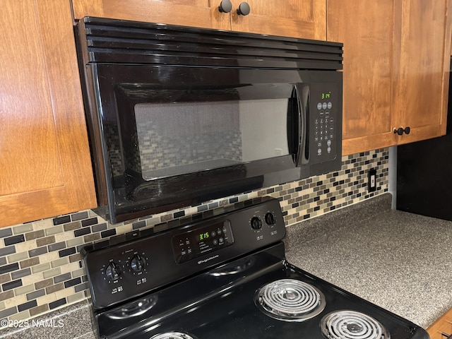 1385 W University Ave Unit 196, Flagstaff, AZ 86001 - kitchen view of black appliances, tasteful backsplash, dark countertops, and brown cabinetry