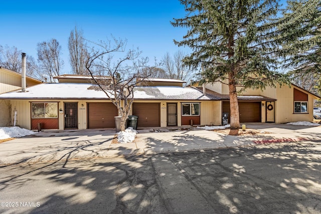 mid-century home featuring an attached garage and driveway