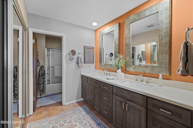 2900 N Saddleback Way Unit 9, Flagstaff, AZ 86004 - bathroom with tile patterned floors, bath / shower combo with glass door, a textured ceiling, and vanity