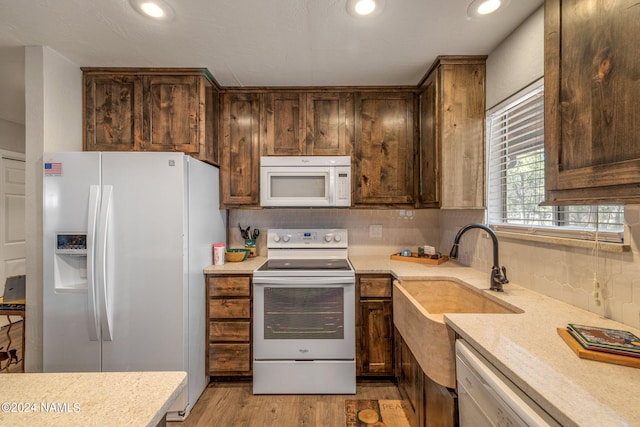 kitchen with sink, white appliances, and light hardwood / wood-style flooring