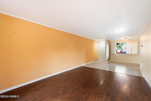 empty room with crown molding and light wood-type flooring