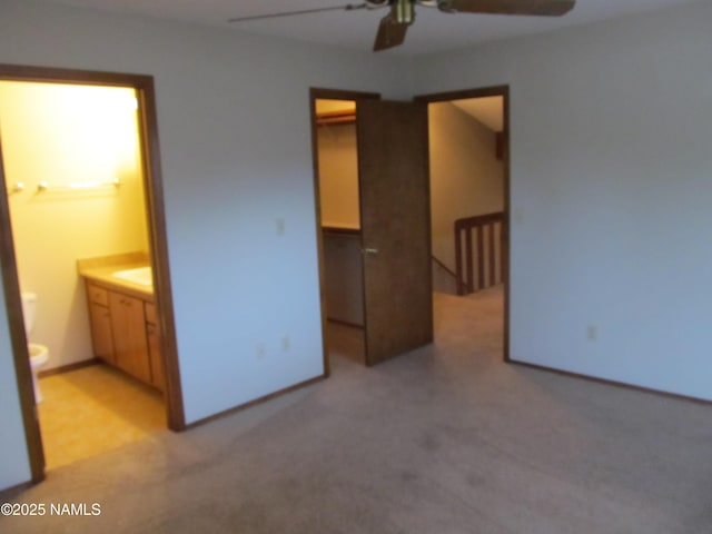 2422 N Whispering Pines Way, Flagstaff, AZ 86004 - unfurnished bedroom featuring a walk in closet, carpet flooring, ensuite bathroom, a closet, and a ceiling fan
