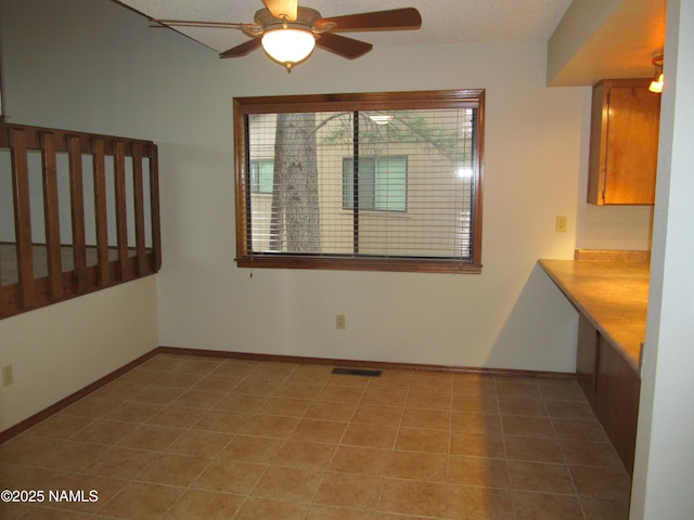 2422 N Whispering Pines Way, Flagstaff, AZ 86004 - unfurnished dining area with ceiling fan, light tile patterned floors, and baseboards