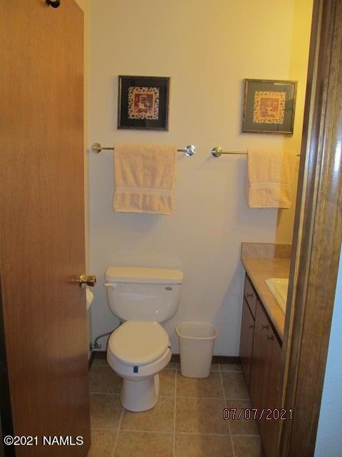 2422 N Whispering Pines Way, Flagstaff, AZ 86004 - bathroom with vanity, toilet, and tile patterned floors