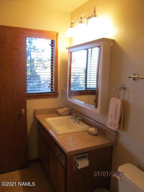 2422 N Whispering Pines Way, Flagstaff, AZ 86004 - bathroom with vanity, toilet, and tile patterned floors