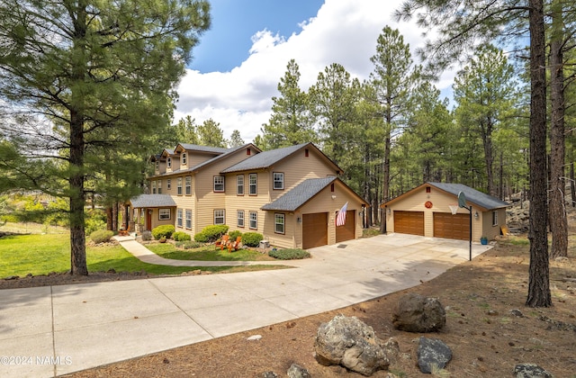 view of front of home featuring a garage, a front yard, and an outdoor structure