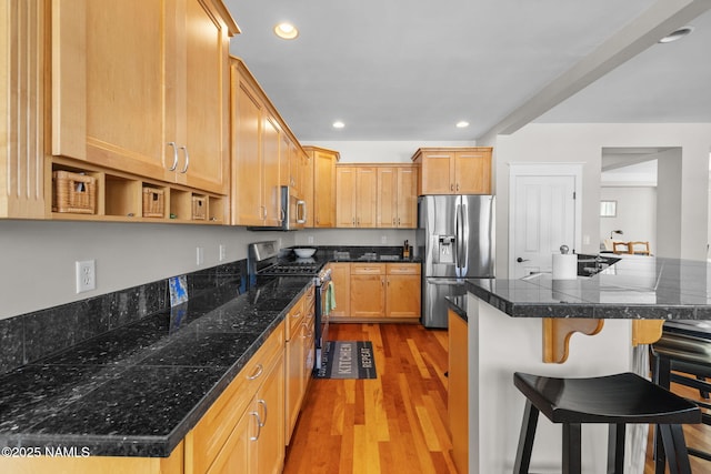 kitchen with recessed lighting, light wood-type flooring, appliances with stainless steel finishes, and a breakfast bar