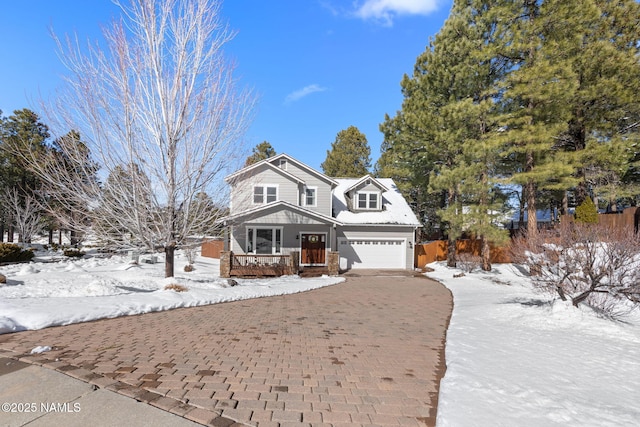 view of front of property with decorative driveway, covered porch, and an attached garage