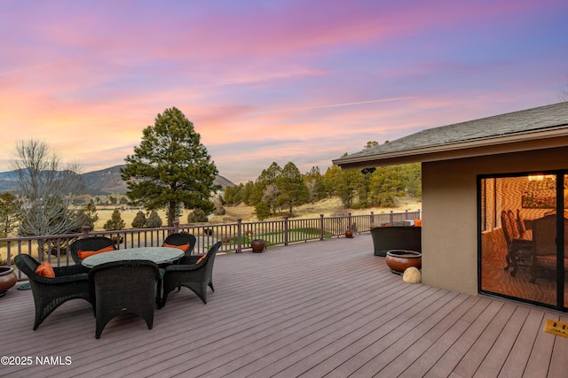 deck at dusk featuring a mountain view