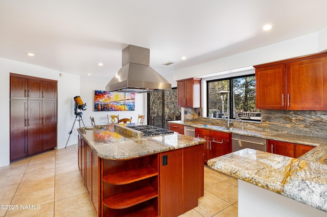 kitchen with island exhaust hood, appliances with stainless steel finishes, a center island, and light stone countertops