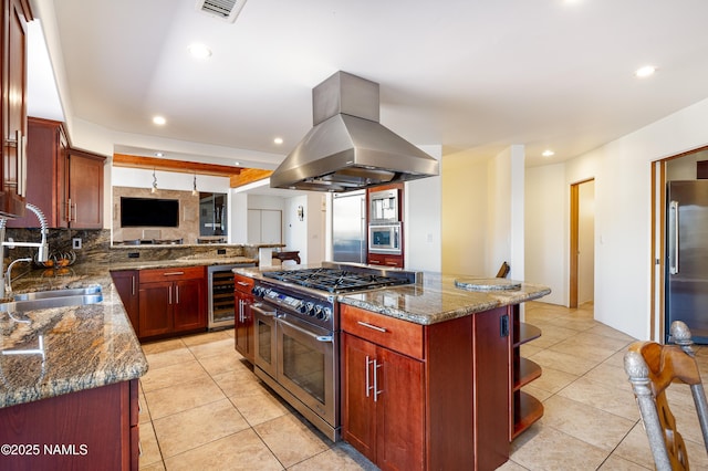 kitchen with a kitchen island, island exhaust hood, appliances with stainless steel finishes, and sink