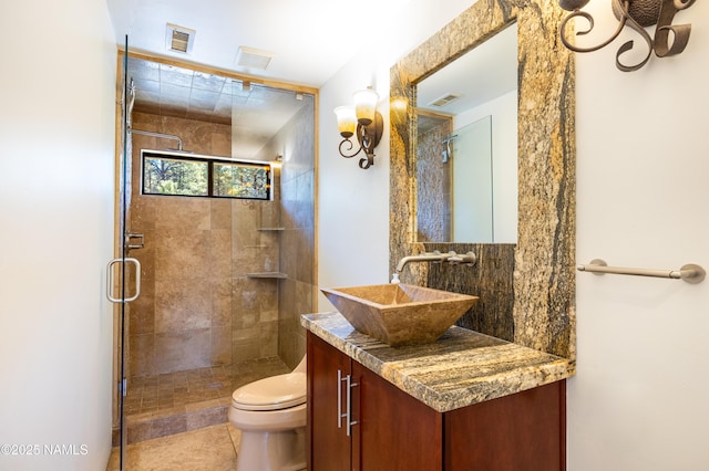 bathroom featuring vanity, a shower with shower door, tile patterned floors, and toilet