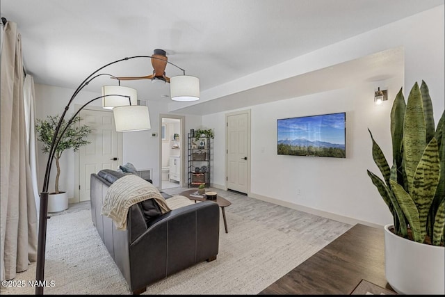 living area featuring baseboards and light wood-type flooring