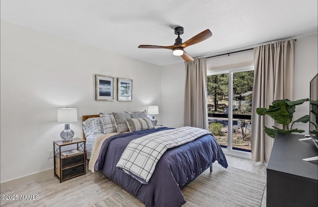 bedroom with baseboards, light wood-type flooring, a textured ceiling, a ceiling fan, and access to outside