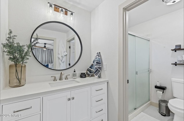 full bathroom featuring vanity, a shower stall, and toilet