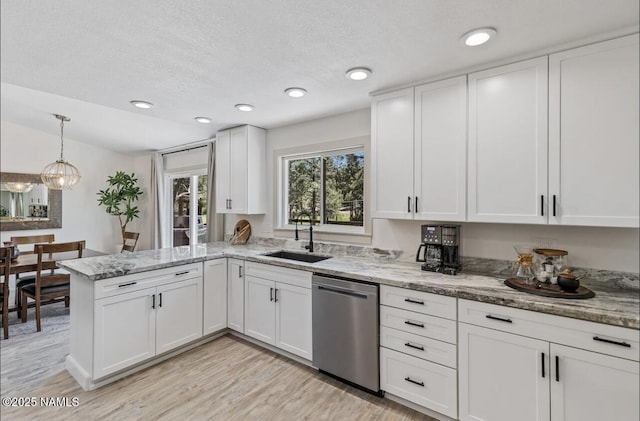 kitchen with light stone counters, a peninsula, a sink, white cabinets, and dishwasher