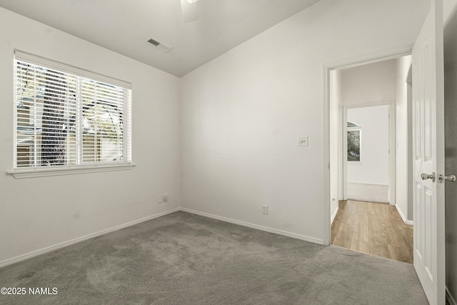 spare room with visible vents, baseboards, and carpet