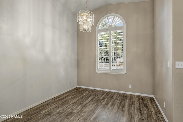 spare room featuring lofted ceiling, a notable chandelier, baseboards, and dark wood-style flooring