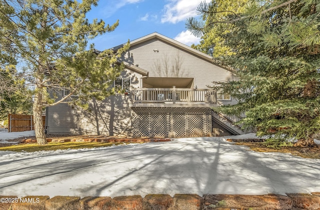 rear view of property with a wooden deck, stairs, and fence