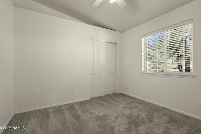 carpeted empty room with ceiling fan, baseboards, and vaulted ceiling