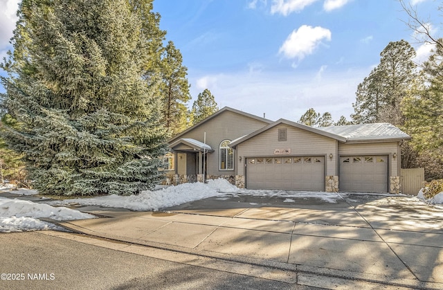 view of front of house featuring concrete driveway, a garage, and stone siding