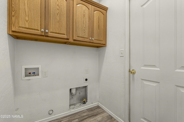 washroom featuring dark wood-type flooring, hookup for a washing machine, hookup for a gas dryer, cabinet space, and electric dryer hookup