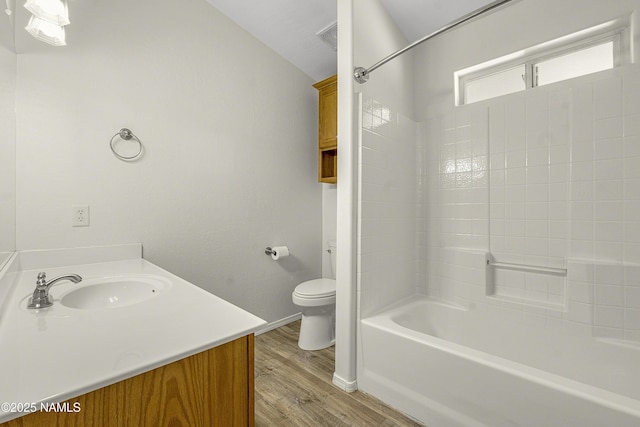 bathroom with visible vents, toilet, shower / bathing tub combination, wood finished floors, and vanity