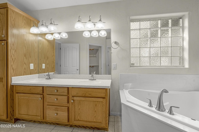 bathroom featuring double vanity, tile patterned floors, a garden tub, and a sink