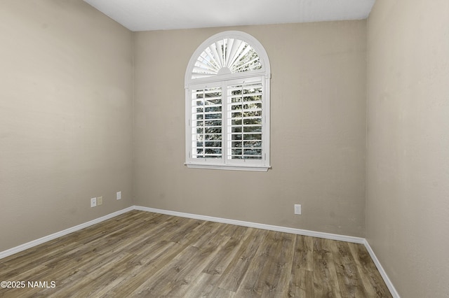 unfurnished room featuring baseboards and wood finished floors