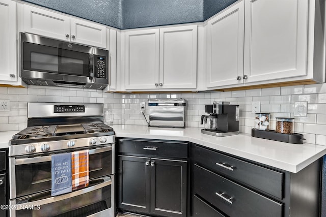 kitchen featuring white cabinets, stainless steel appliances, and tasteful backsplash