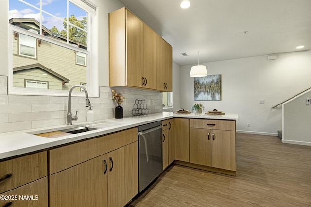 kitchen featuring dishwasher, sink, decorative light fixtures, dark hardwood / wood-style floors, and light brown cabinets