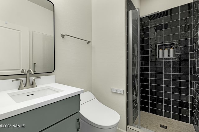 bathroom with toilet, vanity, and a tile shower