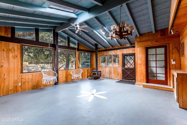 unfurnished sunroom featuring a wood stove and beam ceiling