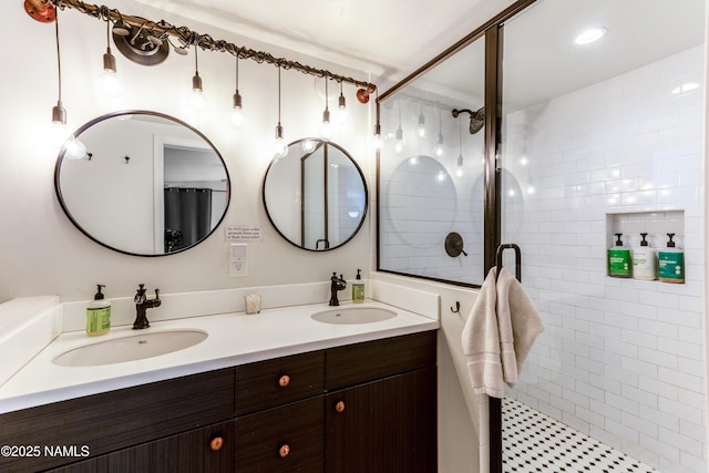 full bath featuring a sink, a shower stall, and double vanity