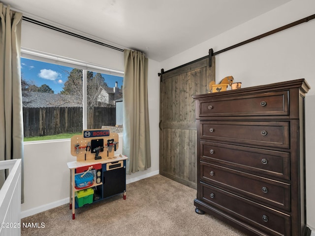 interior space with a barn door, baseboards, a wealth of natural light, and light colored carpet