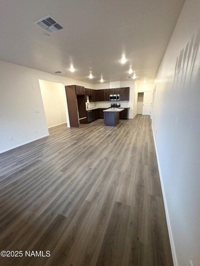 1650 E Ponderosa Pkwy Unit 7-231, Flagstaff, AZ 86001 - unfurnished living room with baseboards, dark wood-style flooring, and visible vents